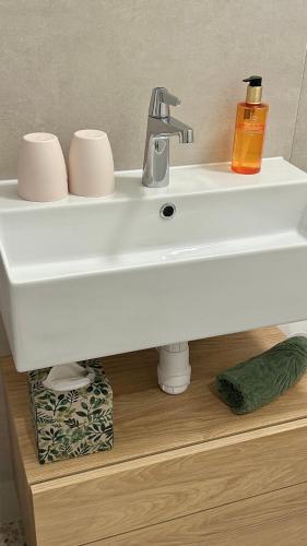 a white bathroom sink with a soap dispenser on it at Omis apartment - near beach and town center, ground floor with small garden in Omiš