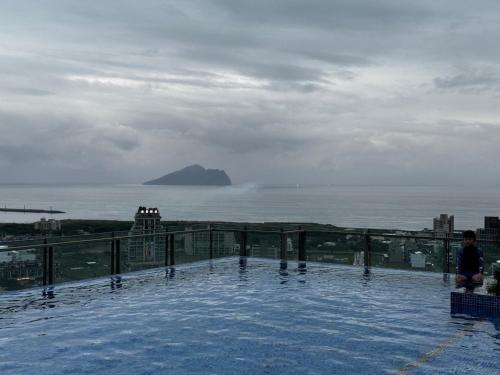a swimming pool on top of a building overlooking the ocean at 宜蘭頭城A Happy Birthday 私人溫泉 海景 蘭陽夜景大陽台無邊際泳池 in Toucheng