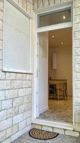 a door leading into a dining room with a window at Omis apartment - near beach and town center, ground floor with small garden in Omiš