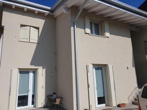 a white house with three windows and a patio at B&B Il Pozzo dei Desideri in Martellago