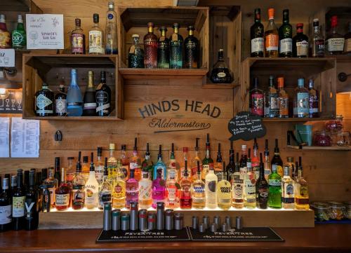 a bar filled with lots of bottles of alcohol at Hinds Head in Aldermaston
