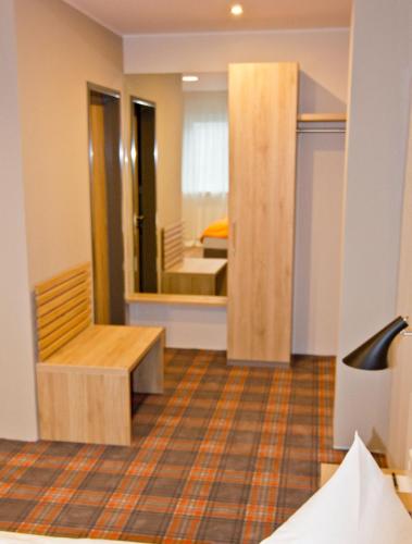 a room with a mirror and a room with a bed at Hotel Alpha in Nürnberg