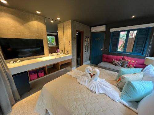 a bedroom with a bed with a swan on it at Pousada Refúgio de Maresias in Maresias