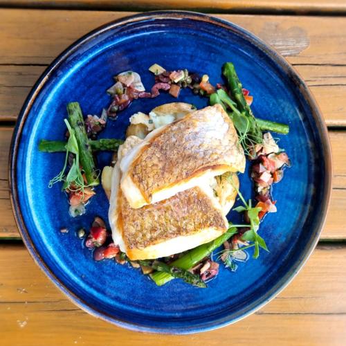 a blue plate of food with a sandwich and vegetables at Hinds Head in Aldermaston