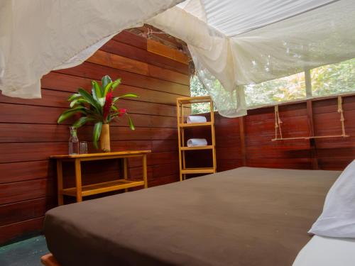 a bedroom with a bed and a table and a window at Hacienda Herrera Tambopata in Puerto Maldonado