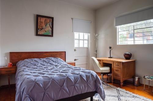 a bedroom with a bed and a desk and a chair at Uotan in Mexico City
