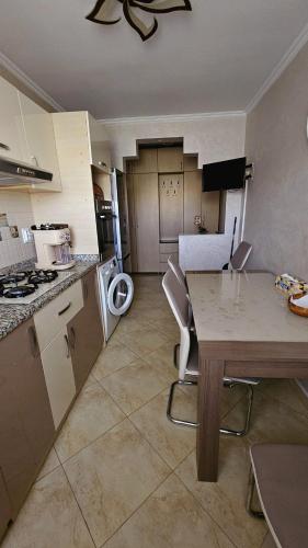 a kitchen with a table and a dining room at Cozy residence in Buzău