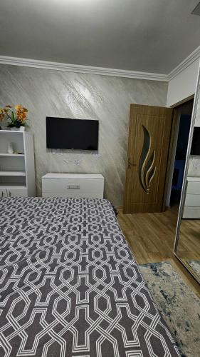 a bedroom with a bed and a flat screen tv at Cozy residence in Buzău