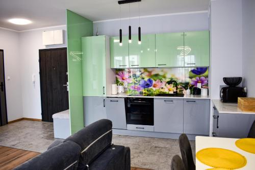 een keuken met groene en witte kasten en een tafel bij Kamienica Nova VITORE 116 in Szczecin