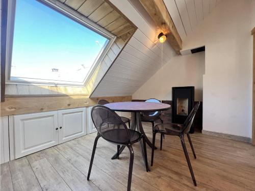a room with a table and chairs and a window at appartement centre ville in Embrun