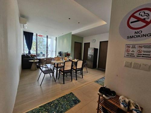 a dining room and living room with a table and chairs at Kenyalang Roxy Sematan Homestay in Sematan
