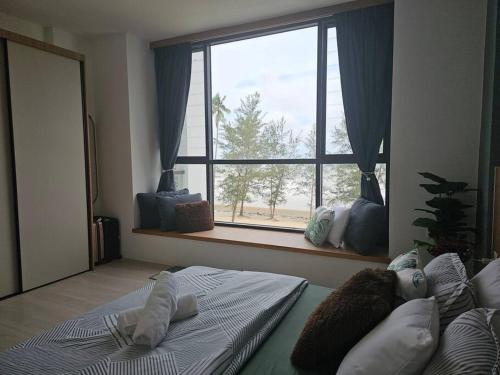 a bedroom with a bed and a large window at Kenyalang Roxy Sematan Homestay in Sematan