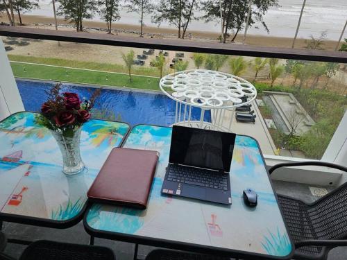 a table with a laptop computer on top of a balcony at Kenyalang Roxy Sematan Homestay in Sematan