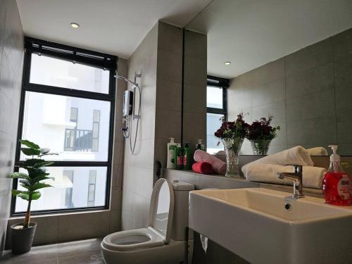 a bathroom with a sink and a toilet and a window at Kenyalang Roxy Sematan Homestay in Sematan