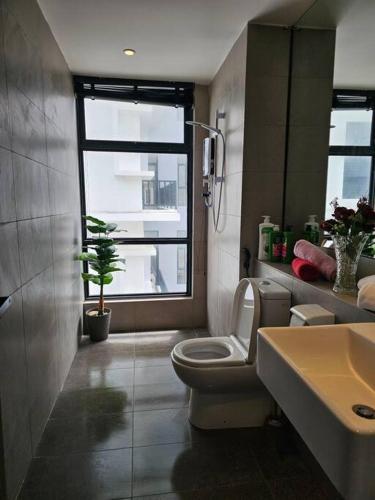 a bathroom with a toilet and a sink and a window at Kenyalang Roxy Sematan Homestay in Sematan