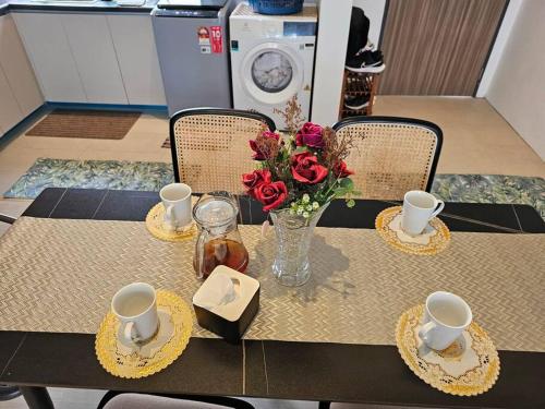 a table with a vase of flowers on it at Kenyalang Roxy Sematan Homestay in Sematan