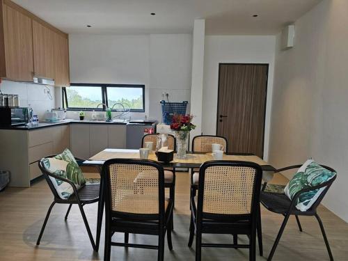 a dining room table and chairs in a kitchen at Kenyalang Roxy Sematan Homestay in Sematan