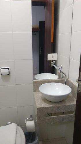 a bathroom with a white sink and a toilet at Alliance Hotel in Bauru