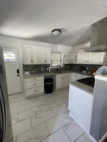 a kitchen with white cabinets and a tile floor at Home in Fort Worth in Fort Worth