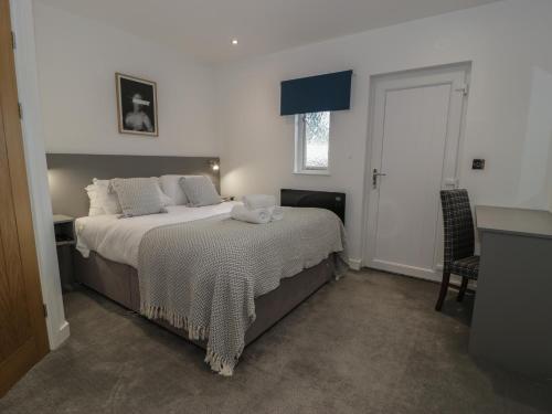 a bedroom with a bed with white sheets and a window at Luxury Lodge 69 in Rhyl