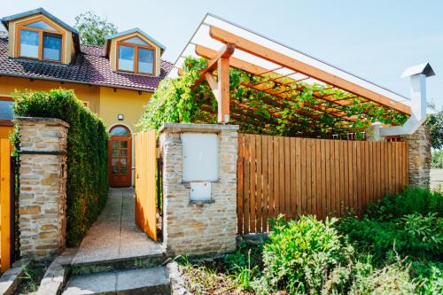 a house with a fence and a wooden gate at Penzion U maléřa in Hroznová Lhota
