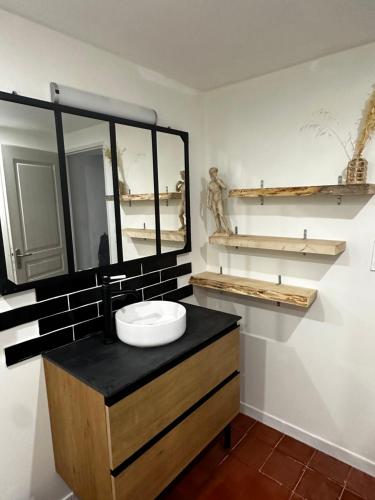 ein Badezimmer mit Waschbecken und Spiegel in der Unterkunft Charmante maison de 4 chambres in Bergerac