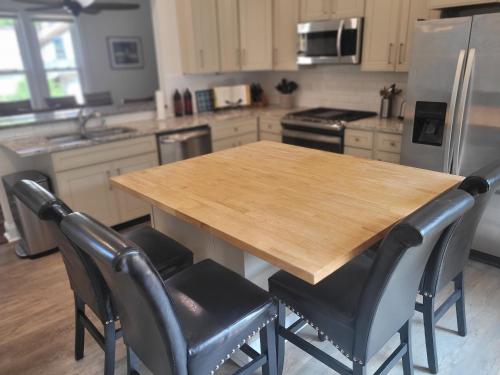 a kitchen with a wooden table and four chairs at The Glarum House - Gorgeous Historic Home & Ac! in Elberta