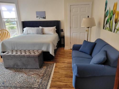 a bedroom with a bed and a blue couch at The Glarum House - Gorgeous Historic Home & Ac! in Elberta