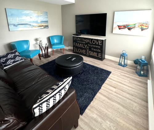 a living room with a couch and a flat screen tv at White Rock Beach getaway in White Rock