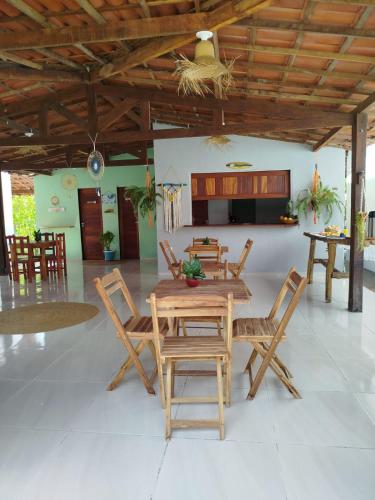a dining room with a wooden table and chairs at Villa dos Coqueirais in Icaraí