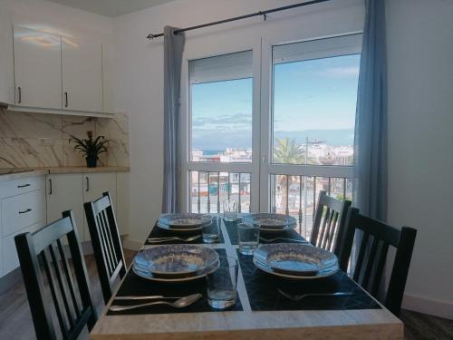 a dining room table with chairs and a view of the city at CASA ALAIA in Arguineguín