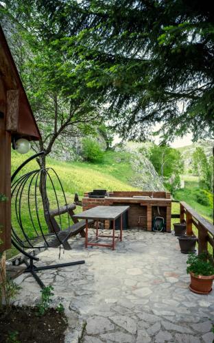 a patio with a picnic table and a bench at Detached house Milivoje in Pošćenje