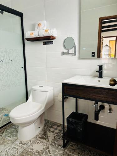 a bathroom with a white toilet and a sink at Hotel Boutique La Mansión Guadalajara in Guadalajara
