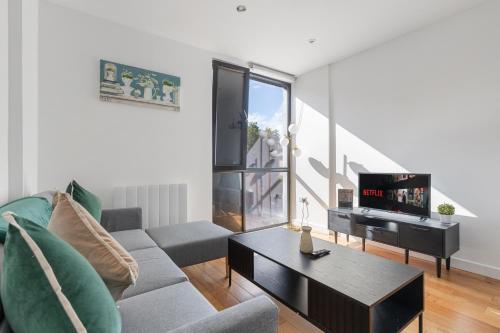 a living room with a couch and a tv at Central Town Centre Gatwick Free Parking in Crawley