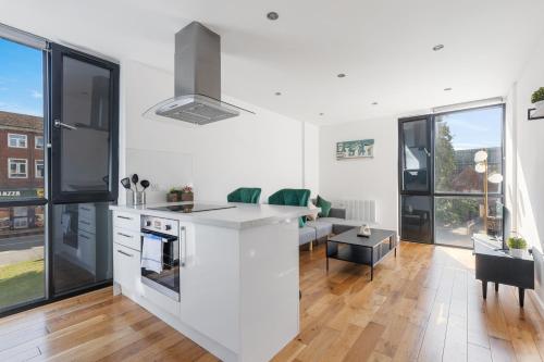 a kitchen and living room with white walls and windows at Central Town Centre Gatwick Free Parking in Crawley