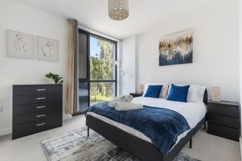 a bedroom with a bed and a large window at Central Town Centre Gatwick Free Parking in Crawley