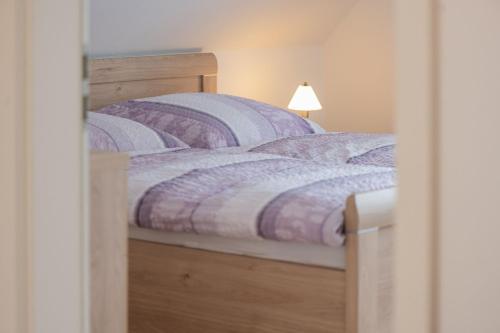 two beds with purple comforters in a bedroom at Ferienwohnung Am Walde 35177 in Hesel