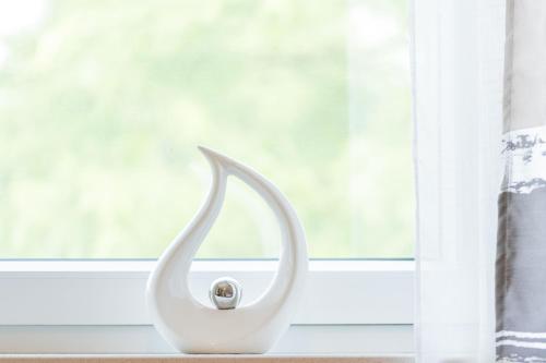a white object sitting on a window sill at Ferienwohnung Am Walde 35177 in Hesel