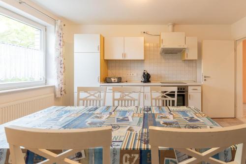 a kitchen with a table and chairs in a room at Ferienwohnung Am Walde 35177 in Hesel