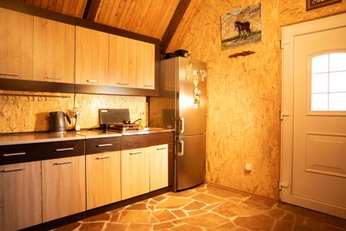a kitchen with wooden cabinets and a refrigerator at Detached house Milivoje in Pošćenje