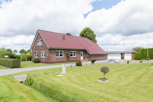 a brick house with a red roof at Ferienwohnung Landleben 35195 in Hesel