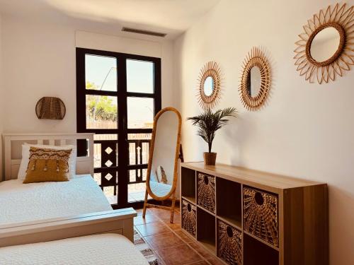 1 dormitorio con cama y espejos en la pared en Take It EaSea, en San Miguel de Abona