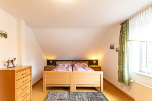 a bedroom with a bed and a dresser and a window at Ferienwohnung Hillers, 35218 in Beningafehn