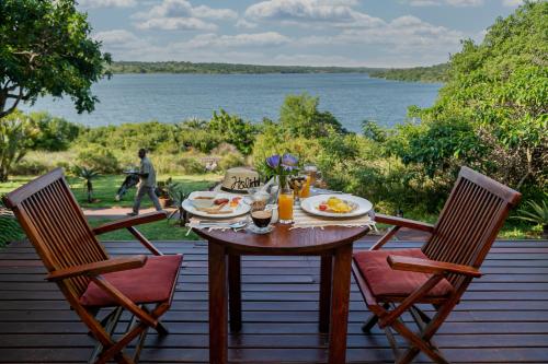 a table on a deck with a view of the water at Naara Eco Lodge & Spa in Chidenguele
