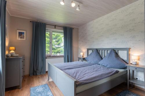 a bedroom with a large bed with blue pillows at Huus de Freese 35224 in Beningafehn