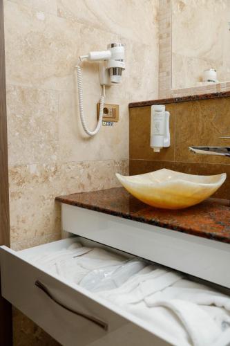 a bathroom with a counter with a bowl sink at Pensiunea Natalya in Bacău