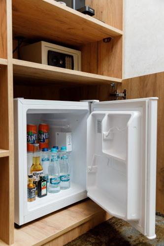 an open refrigerator with drinks in it in a kitchen at Pensiunea Natalya in Bacău