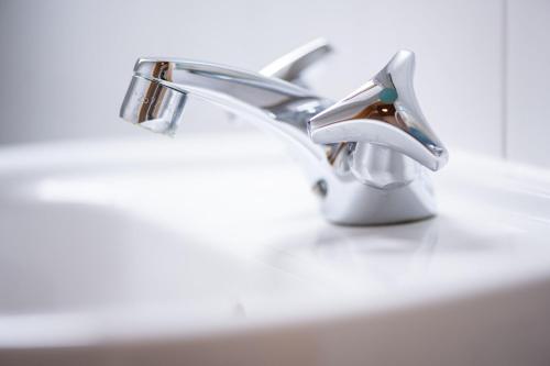 a close up of two faucets on a sink at Ferienwohnung Pop s Huus 35226 in Holtland
