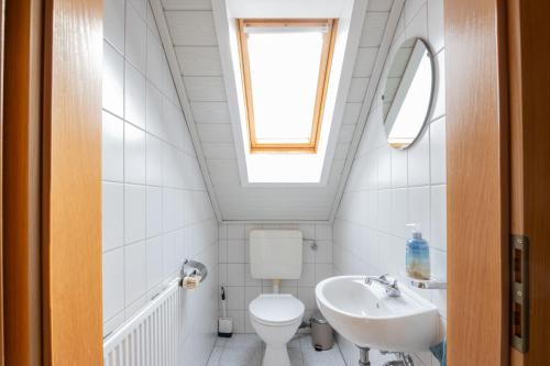a bathroom with a toilet and a sink and a window at Ferienwohnung Pop s Huus 35226 in Holtland