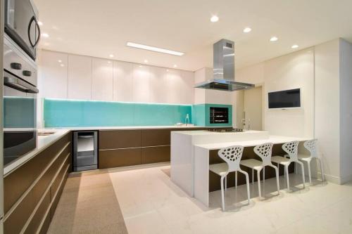 a kitchen with a counter and stools in it at Casa Design Privacidade Familiar in Balneário Camboriú